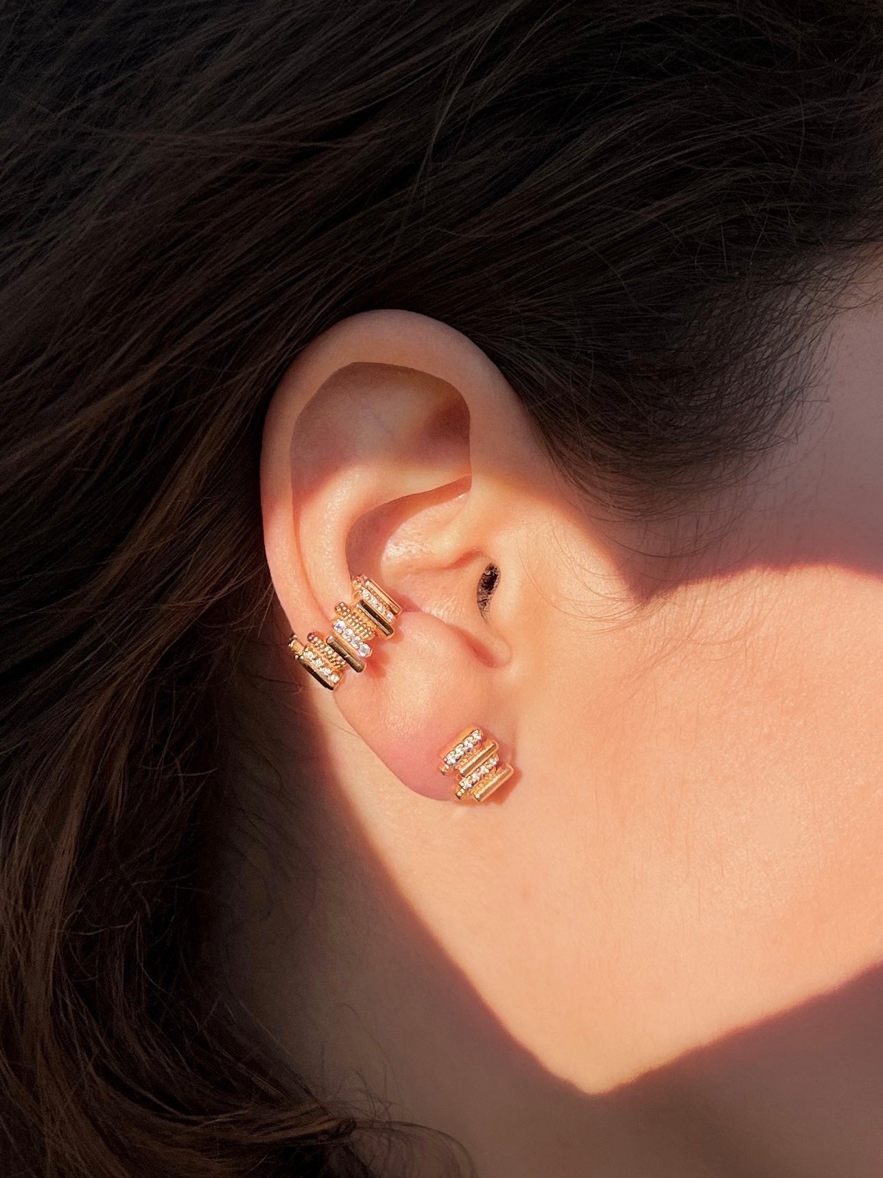 Close up image of LAVERTUE fine earrings, worn by a feminine and delicate model, inspired by a timeless fable about patience and healing. Designed in Montreal, available in solid yellow gold and 24k vermeil, with zircon or diamond stones.