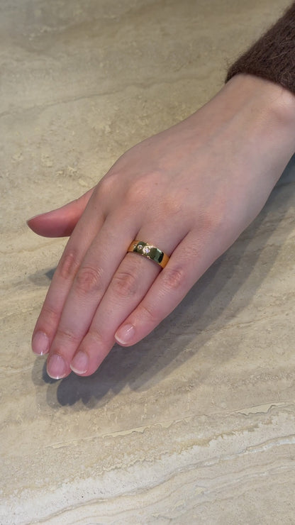 Video showcasing a hand model wearing DOLCE 6mm ring in yellow gold on an ivory marble stand.
