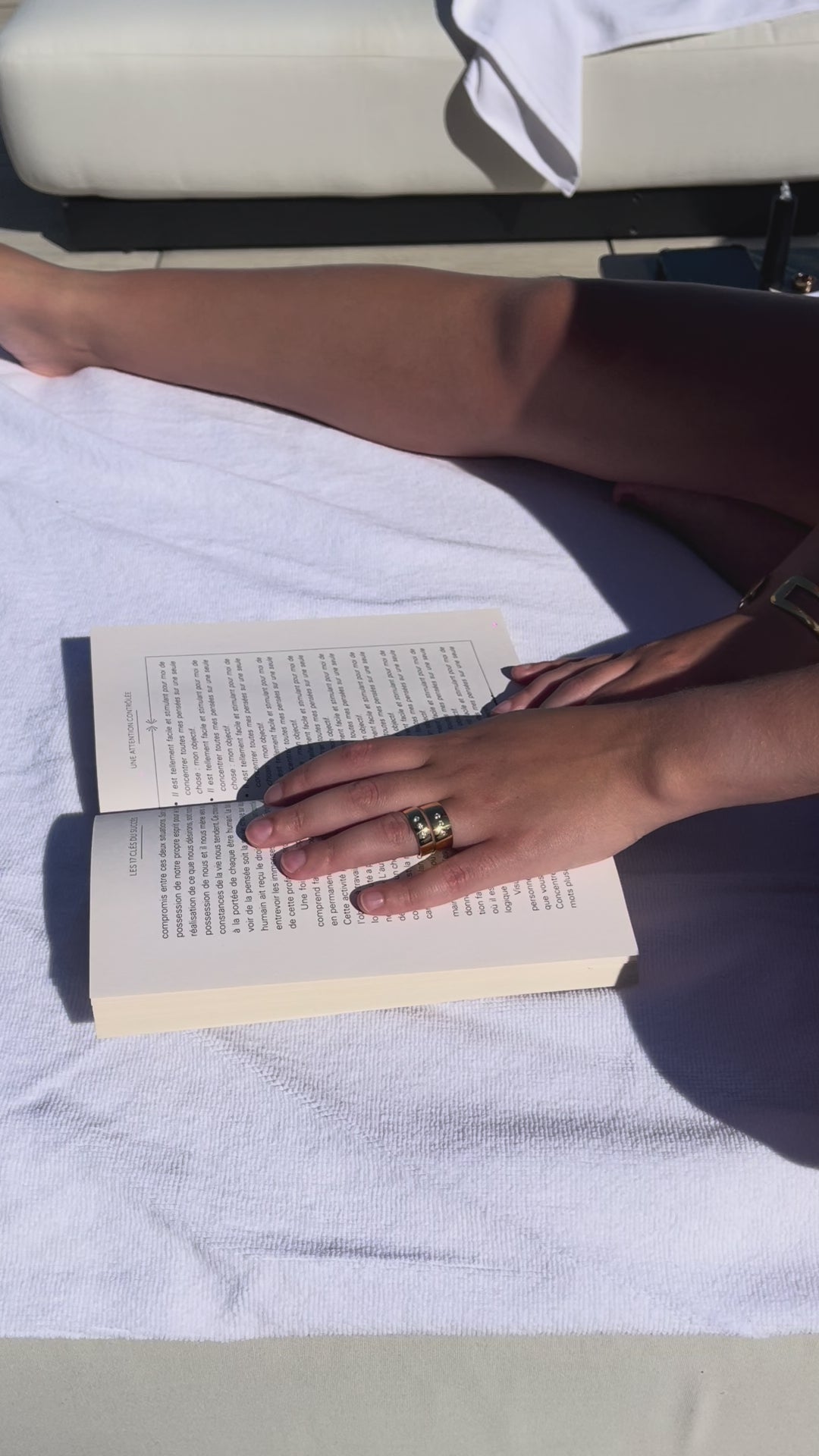 DOLCE rings worn in summer by a model chilling and reading by the pool in downtown montreal.